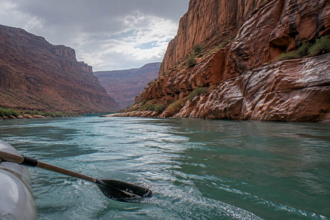 Calm turquoise water of the Colorado River winding through red rock walls near Horseshoe Bend