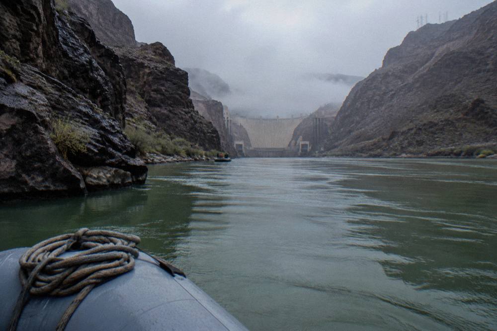 Smooth green water of the Colorado River winding between steep rock walls below Hoover Dam