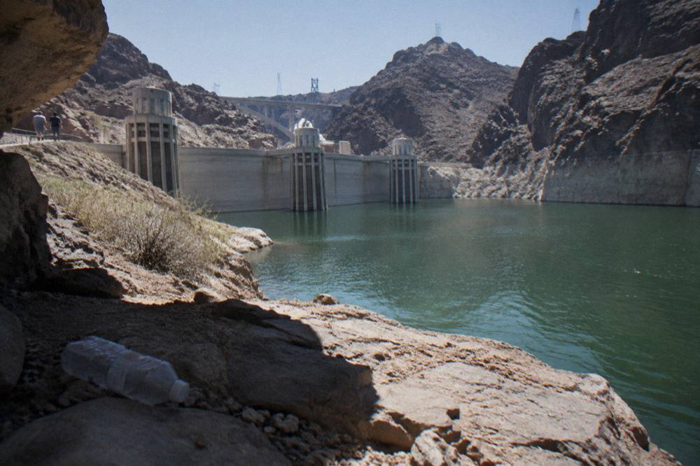 Dark canyon walls rising above the calm green surface of the Colorado River
