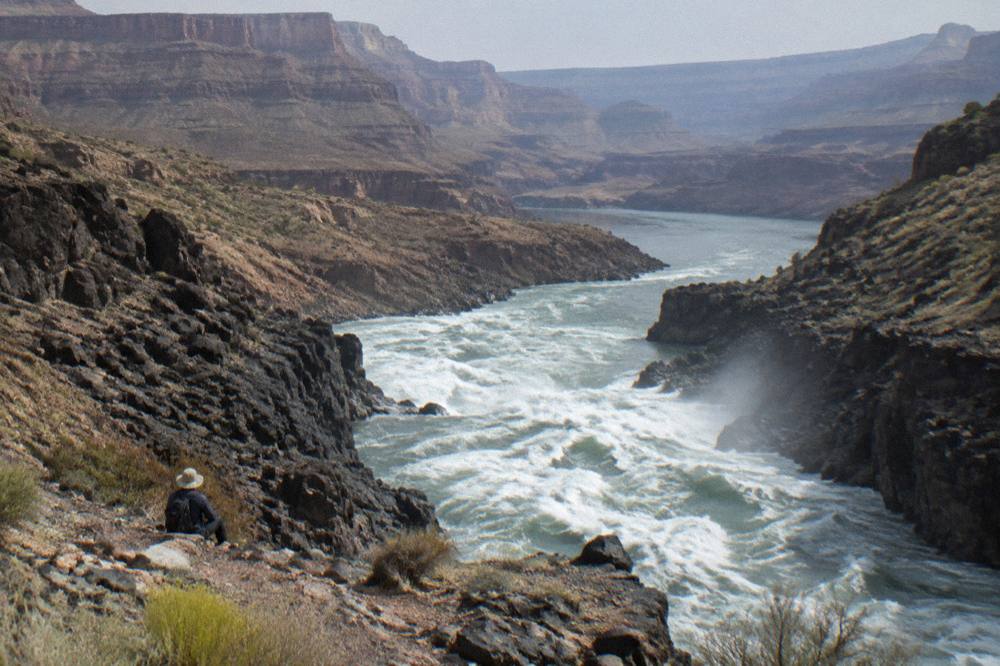 River current moving between rock walls under a wide desert sky