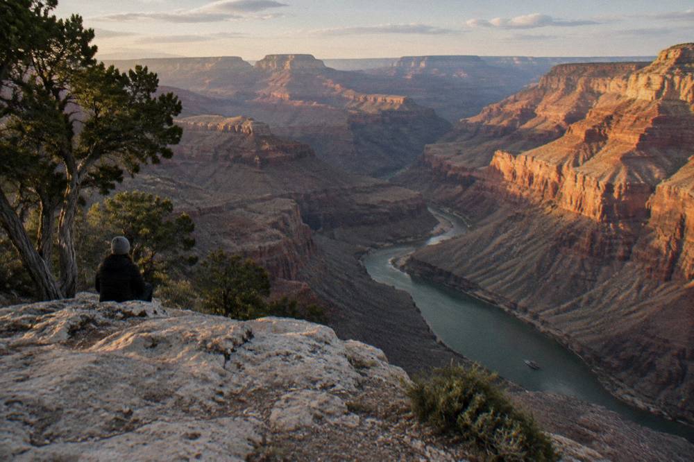 Golden evening light on layered canyon walls above a quiet bend of the river
