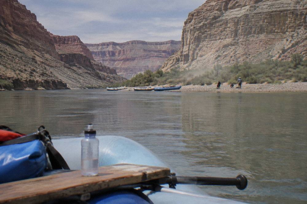 A wide calm river between tall red rock walls under a clear sky