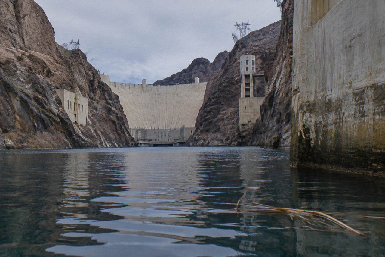Calm blue river water between dark canyon walls below Hoover Dam