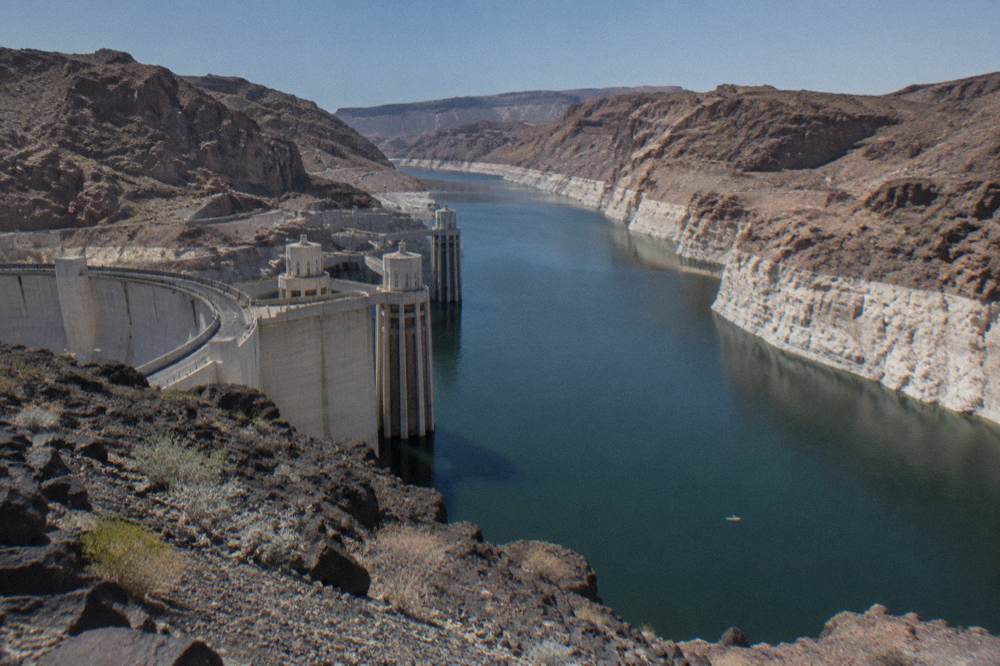 A wide calm river bend with layered rock walls under a clear sky