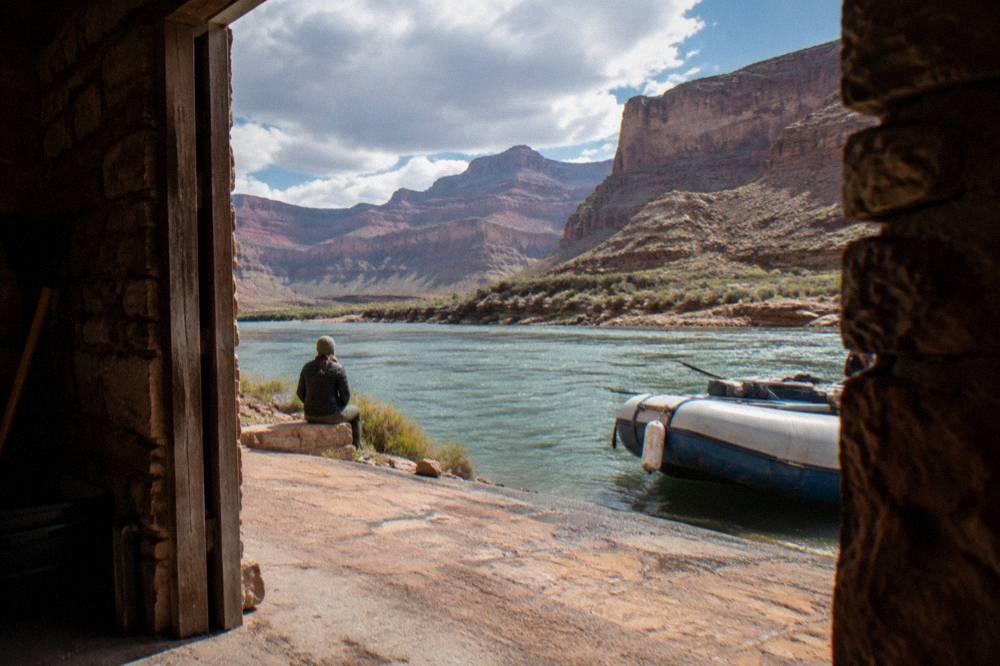 A tour bus parked near the boat ramp at Lees Ferry beside the green Colorado River