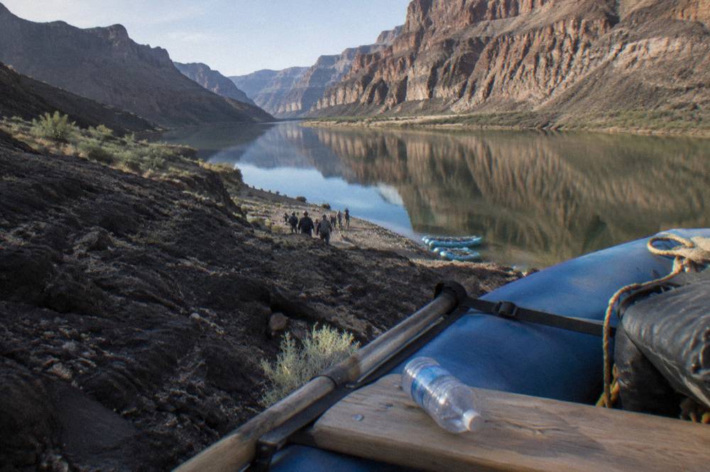 Canyon walls reflected in calm river water at midday