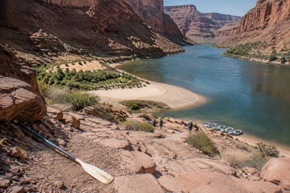 A wide river bend curving between orange sandstone walls under a clear sky