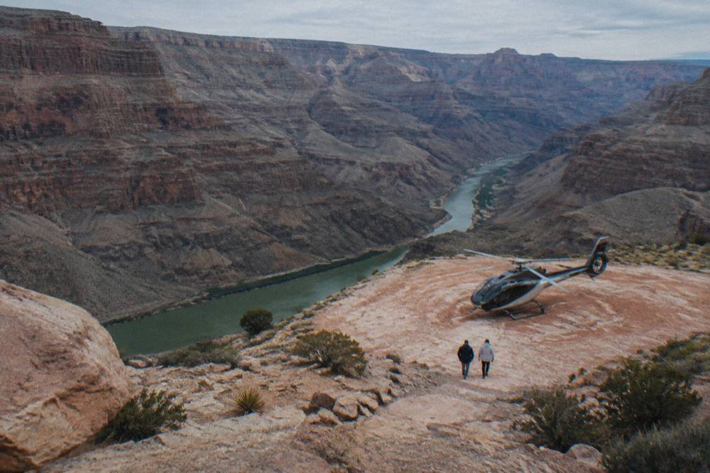 A helicopter parked on a ledge above the Colorado River inside the canyon