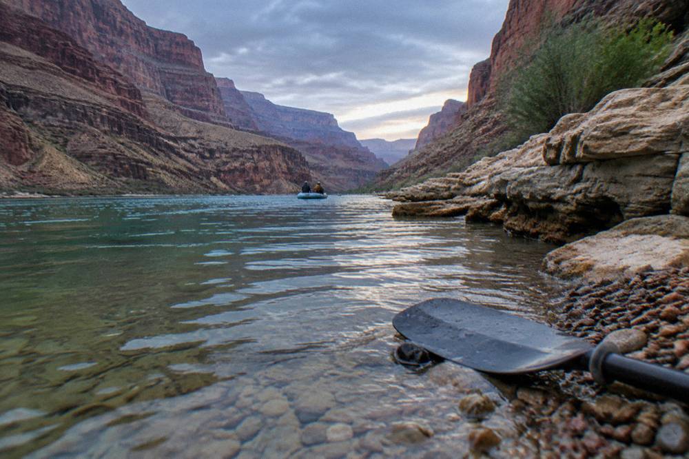 Clear green river water against a rocky shoreline inside a narrow canyon