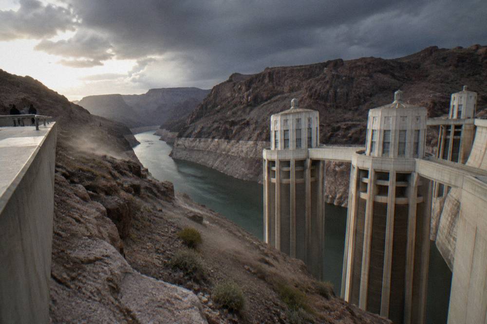 A wide view of Hoover Dam rising above a narrow river corridor